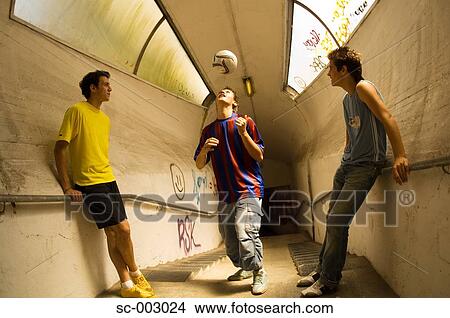 Picture - Teenage boys heading ball in tunnel. Fotosearch