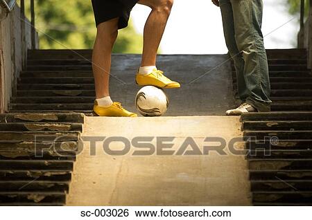 Teenage boys with foot on ball on steps View Large Photo Image Stock Photograph - Teenage boys with foot on ball on steps. Fotosearch