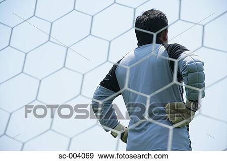 Stock Photo - Back of goalkeeper through net. Fotosearch
