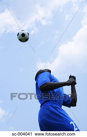 Stock Image - Soccer player heading ball. Fotosearch