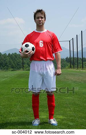 Stock Image - Soccer player holding ball. Fotosearch