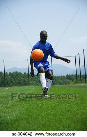 Stock Image - Soccer player juggling ball. Fotosearch