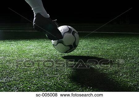 Stock Photo - Close-up of foot kicking soccer ball. Fotosearch
