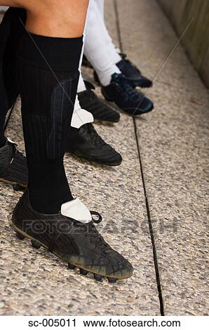 Stock Image - Player legs in substitute dugout. Fotosearch