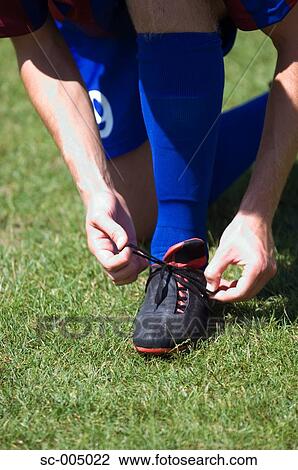 Soccer player tying boot laces View Large Photo Image Stock Image - Soccer player tying boot laces. Fotosearch