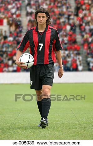 Soccer player walking holding ball View Large Photo Image Stock Photo - Soccer player walking holding ball. Fotosearch