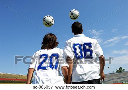 Stock Photo - Two soccer friends wearing 2006 on their shirts and juggling balls. Fotosearch