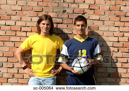Young friends with soccer ball in front of brick wall View Large Photo Image Picture - Young friends with soccer ball in front of brick wall. Fotosearch