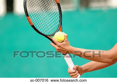 Stock Photograph - Close-Up of Female Tennis Player Holding Ball Serve. Fotosearch
