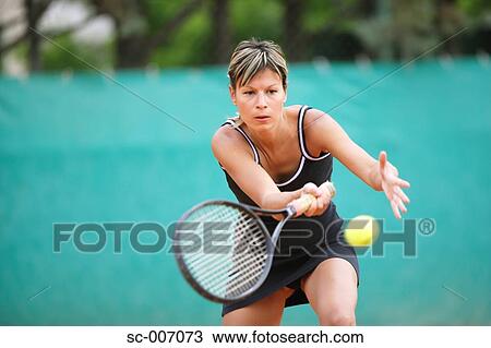 Stock Image - Female Tennis Player Swinging Forehand. Fotosearch