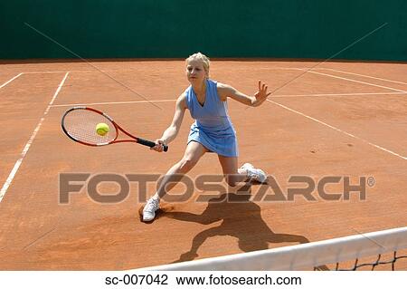 Stock Image - Front View of Female Tennis Player Hitting Ball. Fotosearch