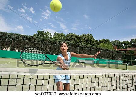 Stock Photo - Front View of Female Tennis Player Hitting Ball. Fotosearch