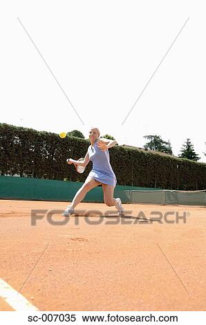 Stock Photography - Front View of Female Tennis Player Hitting Ball. Fotosearch