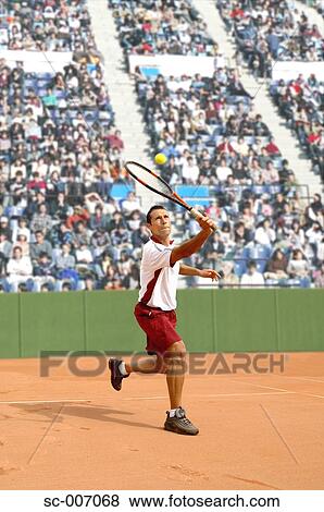 Stock Photo - Male Tennis Player Hitting Ball. Fotosearch
