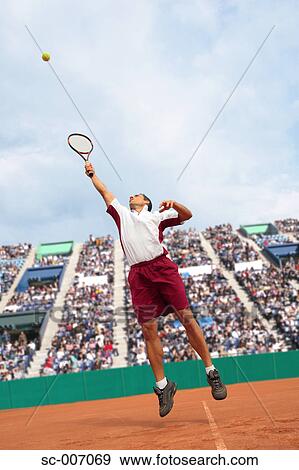 Stock Photo - Male Tennis Player Jumping For Ball. Fotosearch