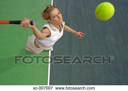 Stock Photo - Top View of Female Tennis Player Mid-Serve. Fotosearch