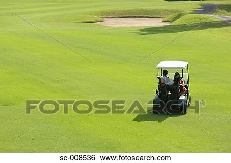 Stock Photograph - Couple Driving a Golf Cart on a Golf Course. Fotosearch