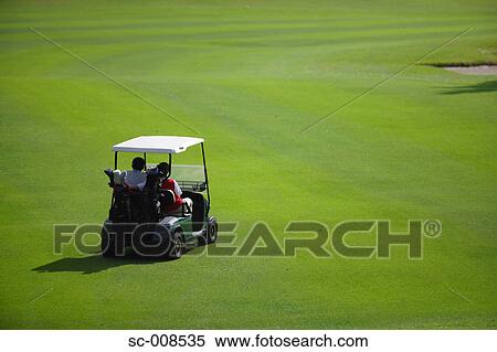 Stock Photography - Couple Driving a Golf Cart on a Golf Course. Fotosearch