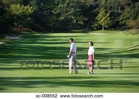 Stock Image - Couple Standing on a Golf Course. Fotosearch