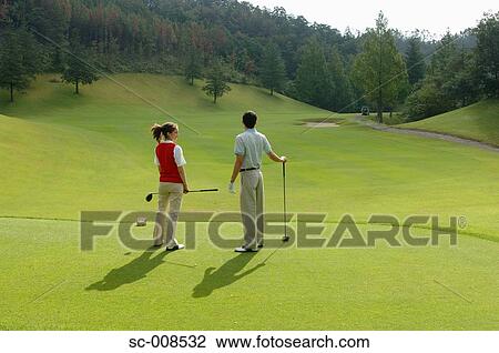 Stock Image - Couple Stands on a Golf Course. Fotosearch