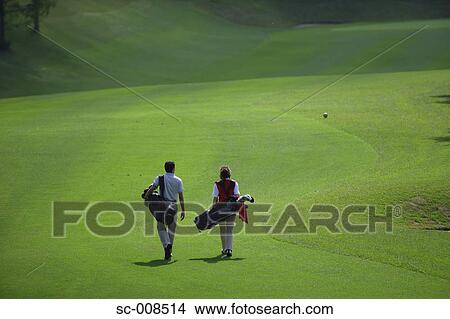Picture - Couple Walks Down the Fairway of a Golf Course. Fotosearch