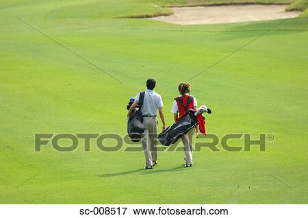 Stock Photo - Couple Walks Down the Fairway of a Golf Course. Fotosearch