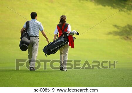 Stock Photo - Couple Walks Down the Fairway of a Golf Course. Fotosearch