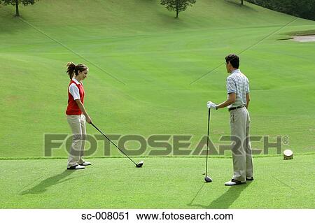 Stock Image - Female golfer lining up her tee shot. Fotosearch
