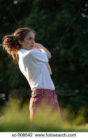 Stock Image - Female Golfer Swinging a Golf Club. Fotosearch