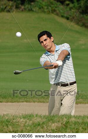 Stock Photograph - Front view of a man playing a bunker shot. Fotosearch