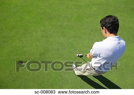 Male golfer making a putt View Large Photo Image Stock Image - Male golfer making a putt. Fotosearch