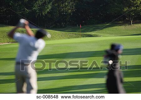 Stock Photo - Male Golfer Swinging a Golf Club. Fotosearch
