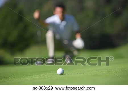 Man Looking at a Golf Ball on a Putting Green View Large Photo Image Stock Photo - Man Looking at a Golf Ball on a Putting Green. Fotosearch
