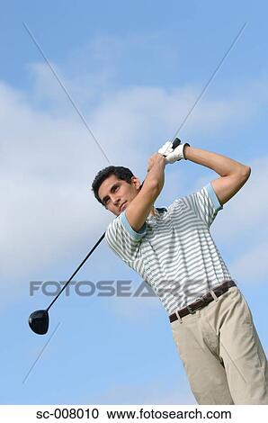 Stock Image - Portrait of a man making a golf swing. Fotosearch