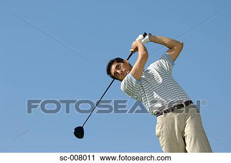 Stock Image - Portrait of a man making a golf swing. Fotosearch