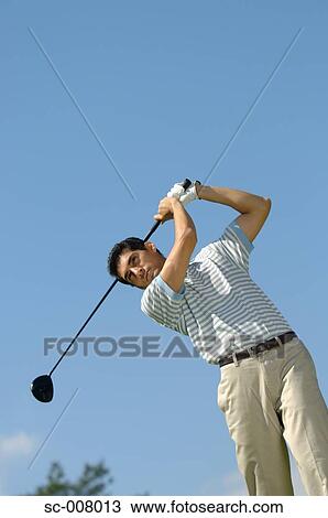 Stock Image - Portrait of a man making a golf swing. Fotosearch