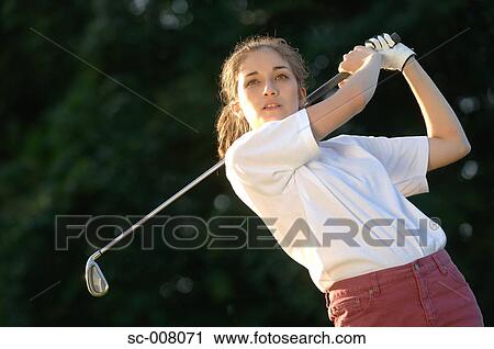 Stock Image - Portrait of a woman holding a golf club. Fotosearch
