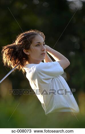 Stock Image - Portrait of a woman holding a golf club. Fotosearch