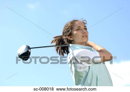Stock Photo - Portrait of a young woman holding a golf club. Fotosearch