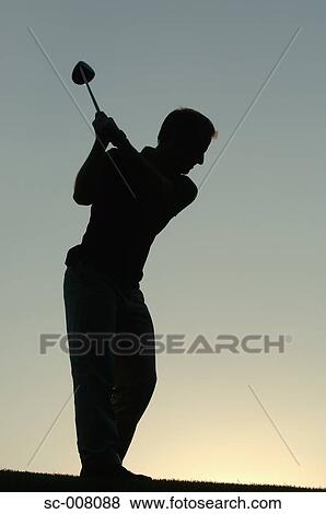 Stock Photo - Silhouette of a man in action hitting a golf shot. Fotosearch