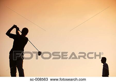 Stock Image - Silhouette of Two Male Golfers Against an Evening Sky. Fotosearch