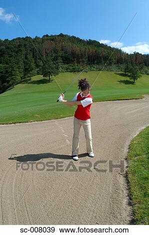 Stock Photo - Woman playing a bunker shot. Fotosearch