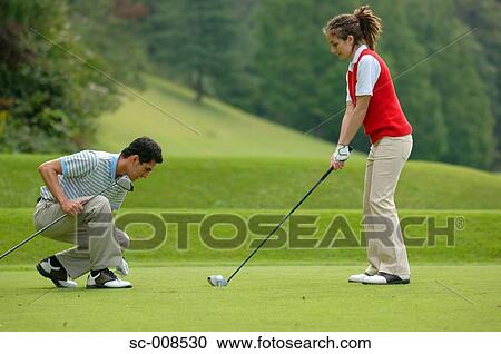 Young Man Teaches a Young Woman How to Play Golf View Large Photo Image Stock Image - Young Man Teaches a Young Woman How to Play Golf. Fotosearch