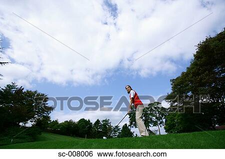 Stock Photograph - Young woman contemplating before playing a golf shot. Fotosearch