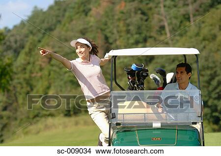 Picture - A woman points out the direction to her golf partner. Fotosearch