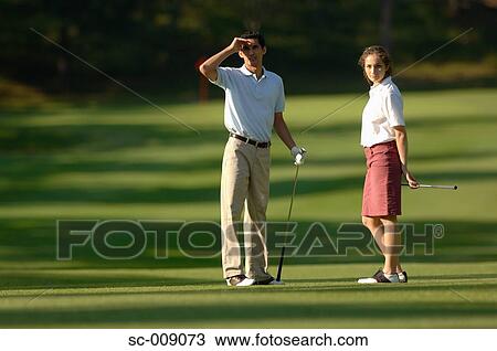Couple examining the golf course on a sunny day View Large Photo Image Stock Image - Couple examining the golf course on a sunny day. Fotosearch
