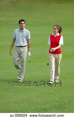 Couple is seen walking down the fairway View Large Photo Image Picture - Couple is seen walking down the fairway. Fotosearch