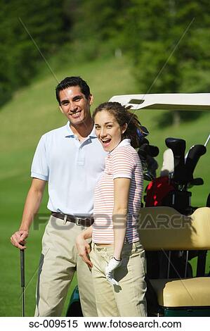 Couple smiling besides a golf cart View Large Photo Image Stock Photography - Couple smiling besides a golf cart. Fotosearch