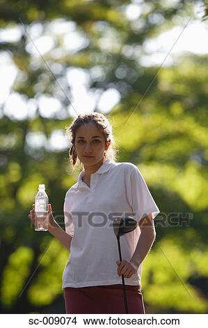 Female golfer taking a drink break View Large Photo Image Picture - Female golfer taking a drink break. Fotosearch