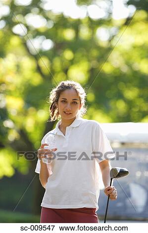 Female golfer taking a drink break View Large Photo Image Stock Photo - Female golfer taking a drink break. Fotosearch